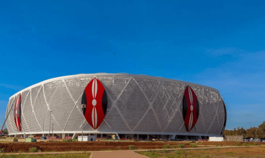 体育场外观的广角照片，显示了外墙上的肯尼亚国徽和正在进行的景观美化工程