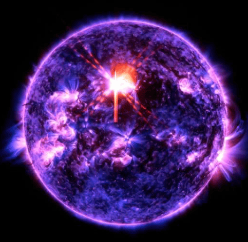 美国宇航局的太阳动力学天文台于2026年2月4日拍摄到了这张太阳耀斑的图像——图中上方中部可见一道明亮的闪光。图像显示的是极紫外光的一部分，它突显了耀斑中极热的物质，并以蓝色和红色着色。