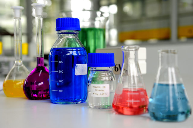 Laboratory glassware containing colorful chemical liquid, lab research and development concept
