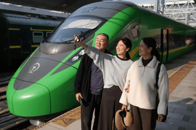 旅客在中老铁路列车前自拍留念。