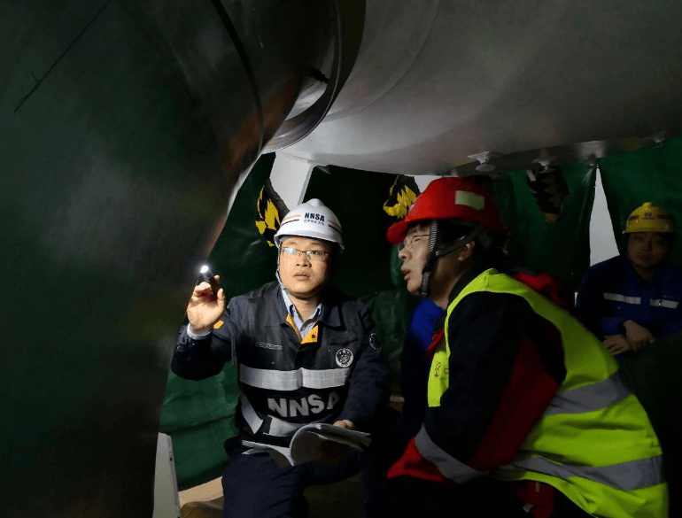 现场监督员在狭小黑暗空间内，对“华龙一号”全球首堆福清核电厂5号机组的主管道焊接施工现场进行检查。