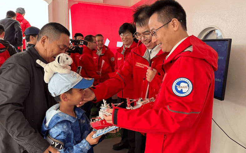小朋友将拼好的“雪龙号”模型送给父亲。