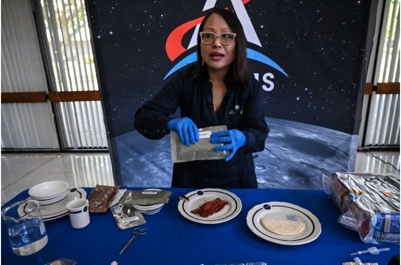 Xulei Wu, a NASA food scientist, displays dishes that were part of the Artemis II crew's meals