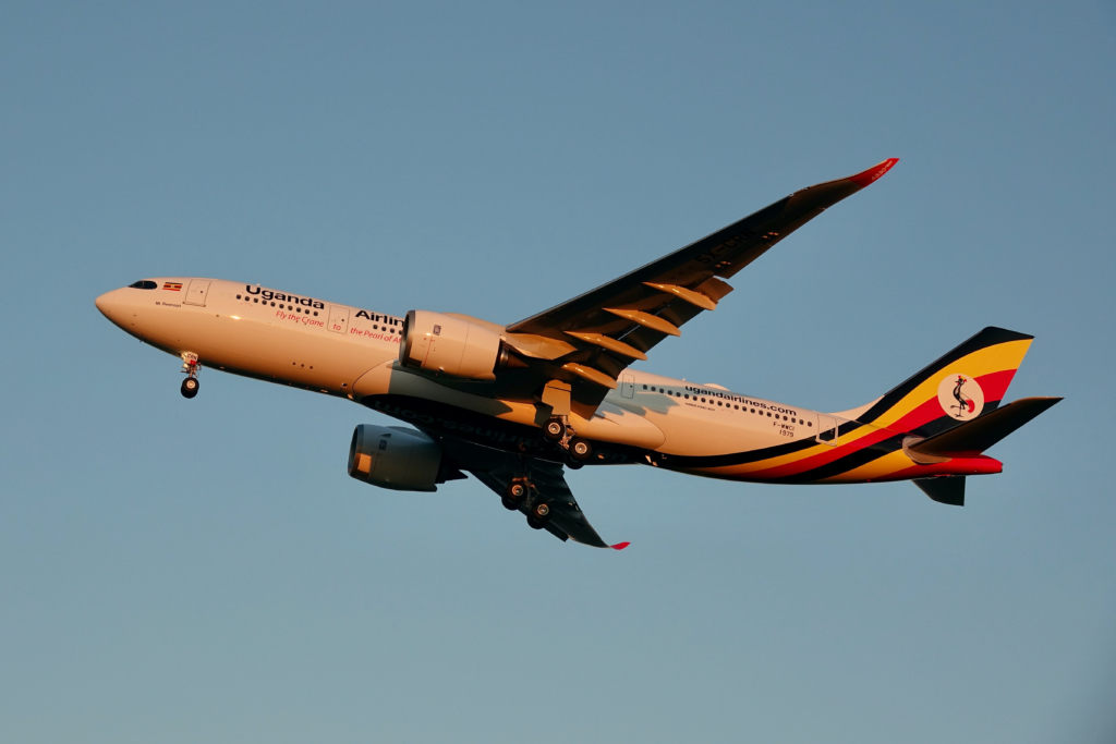 Uganda Airlines A330 landing in the sunlight against a blue sky.