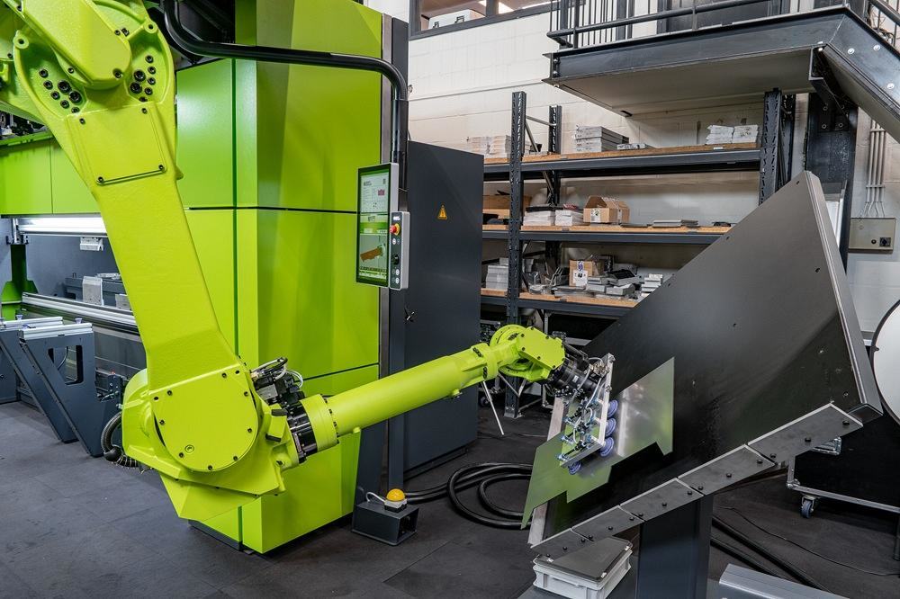 Un robot mueve una pieza metálica.