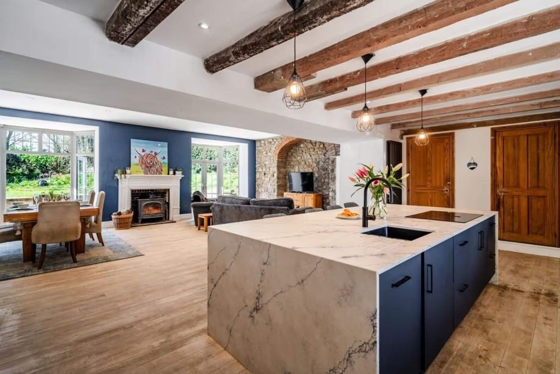 On peut dire que la décision de conception la plus impactante de la maison a été la suppression du mur de séparation entre la cuisine et le salon-salle à manger, créant un espace exceptionnel qui est clairement le cœur du foyer, tout en étant un espace magnifiquement décoré. L'utilisation d'un bleu marine foncé sur l'îlot de cuisine et le mur du fond relie visuellement les différentes zones, et une variété de matériaux naturels tactiles a été employée. Manoir Johnston Hall près de Haverfordwest, mis en vente pour 1,85 million de livres sterling par Fine & Country West Wales (Aberystwyth)