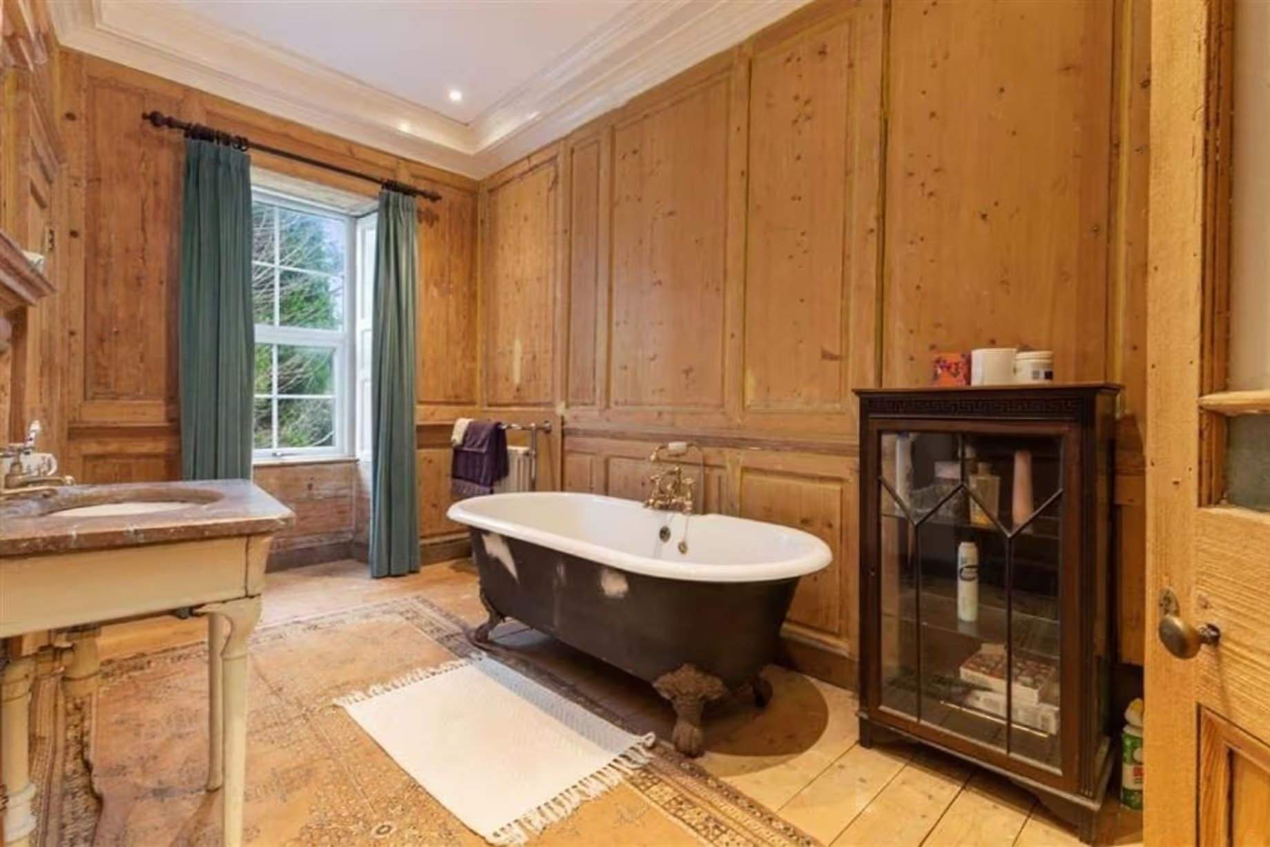 La salle de bains familiale principale avant rénovation possédait de riches lambris et un sol apparent, mais c'est peut-être la corniche foncée qui était l'élément marquant de cet espace. Manoir Johnston Hall près de Haverfordwest, mis en vente pour 1,85 million de livres sterling par Fine & Country West Wales (Aberystwyth)