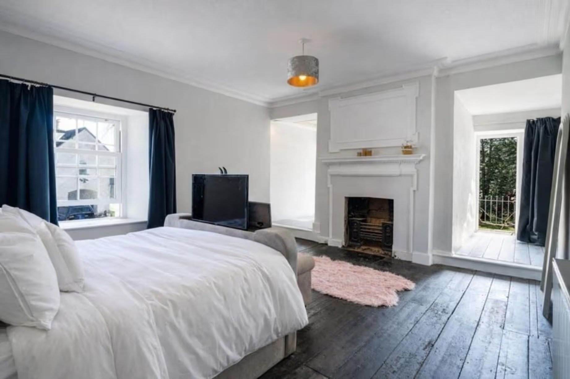 La chambre principale comprend un accès à un balcon privé, peint en blanc, avec un sol apparent. Manoir Johnston Hall près de Haverfordwest, mis en vente pour 1,85 million de livres sterling par Fine & Country West Wales (Aberystwyth)
