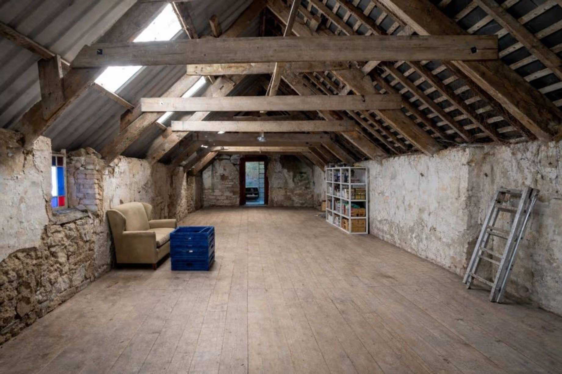 Une vieille grange vide, laissant apparaître poutres et murs en pierre. Manoir Johnston Hall près de Haverfordwest, mis en vente pour 1,85 million de livres sterling par Fine & Country West Wales (Aberystwyth)