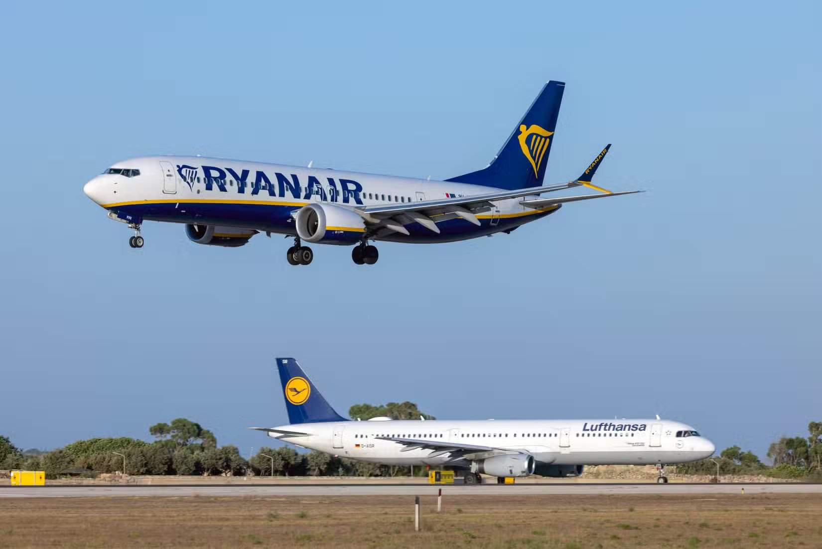 马耳他卢卡,2023年8月2日:瑞安航空(马耳他航空)波音737-8 MAX 200(注册号:9H-VVG)即将着陆,汉莎航空A321(D-AISR)等待起飞许可。