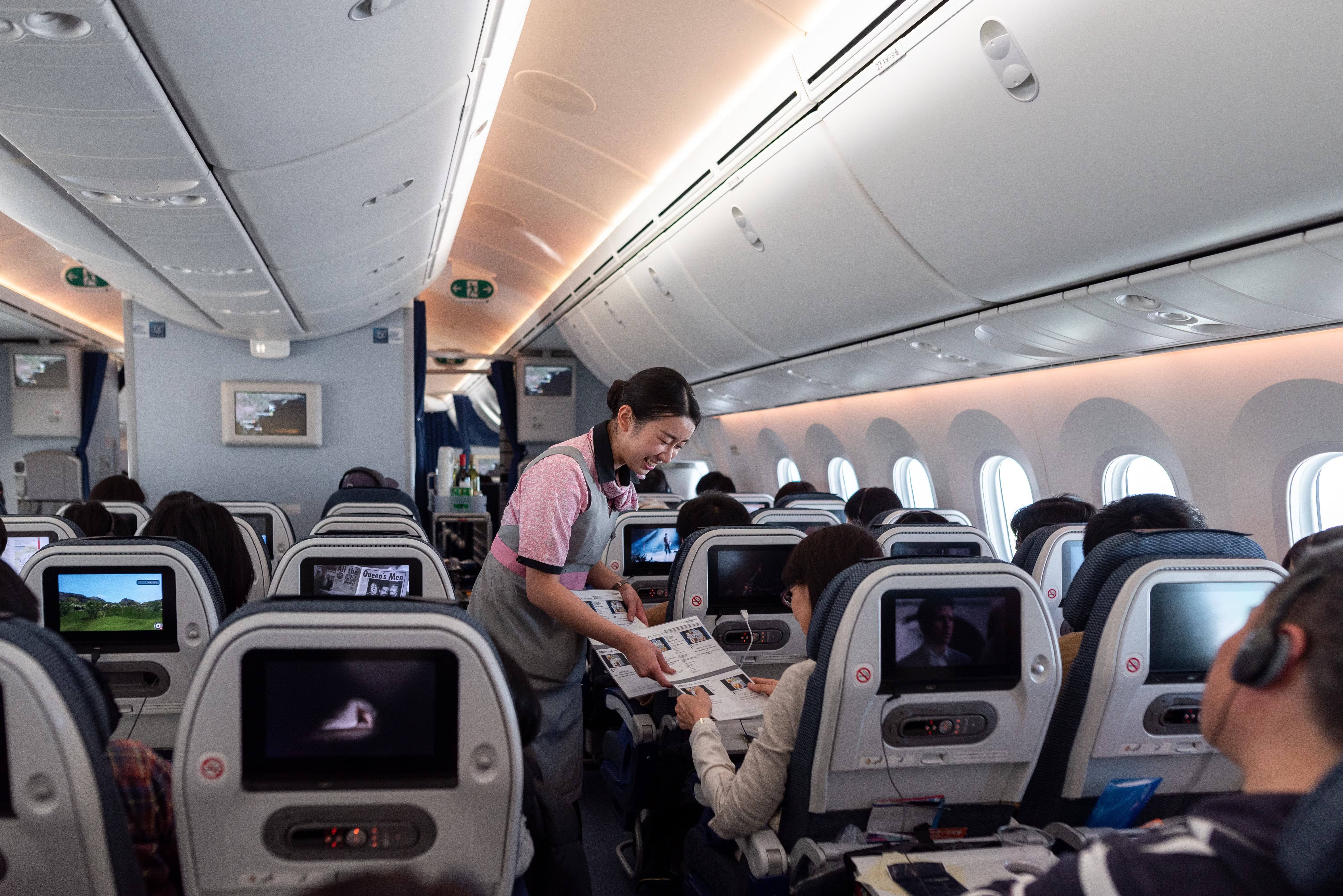 日本全日空航空波音787梦想飞机客舱内景,乘客和空乘人员正在为旅客服务
