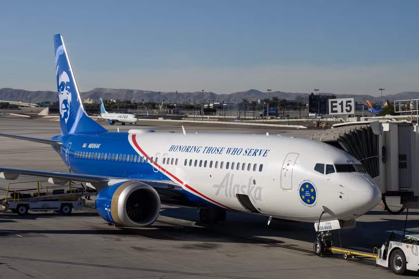 A Boeing 737-8 MAX aircraft operated by Alaska Airlines, featuring a special 'Honoring Those Who Serve' livery.