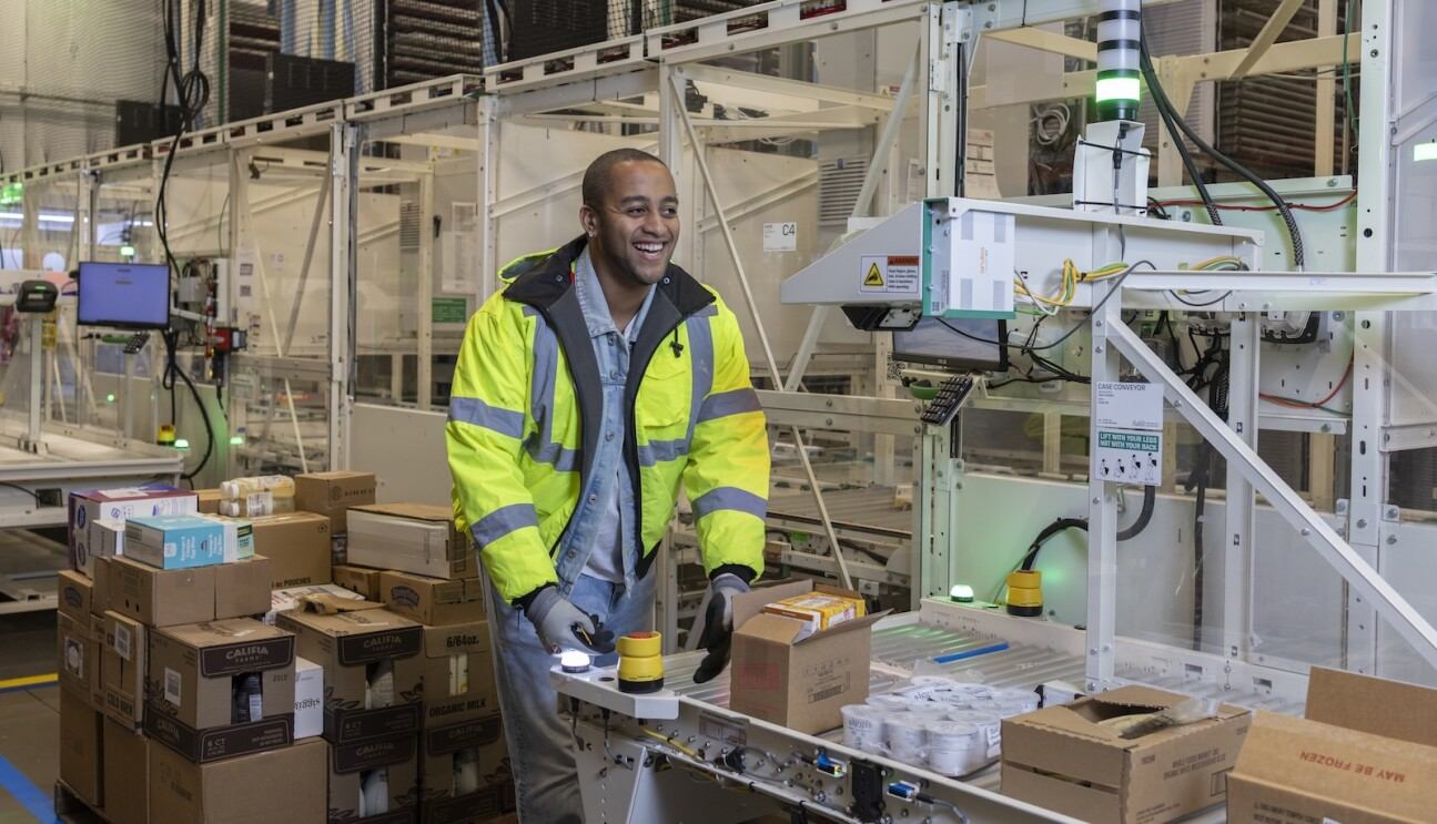 الموظف في أمازون تري هوارد يعمل مع روبوت ShopBot داخل مركز التوزيع الصغير الآلي في متجر هول فودز في بليموث ميتينغ بولاية بنسلفانيا