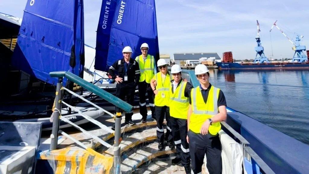 Un grupo de trabajadores masculinos de pie en la popa del barco de crucero