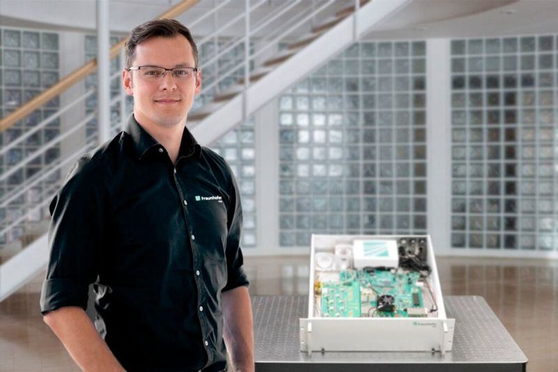 Alexander Noack站在QRNG R19-Zoll演示器旁。(图片来源:Fraunhofer IPMS)