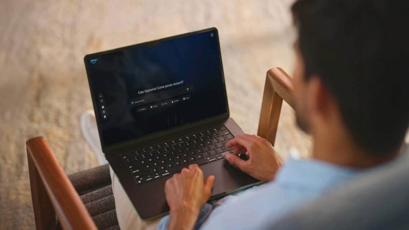 Мужчина сидит в кресле и использует Alexa+ на ноутбуке