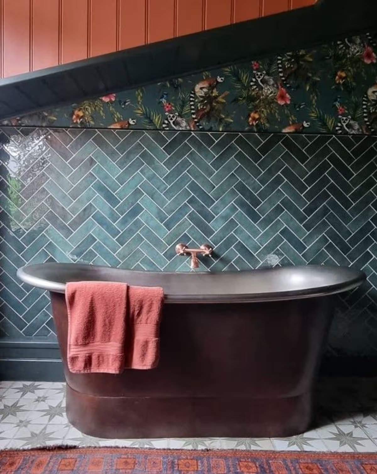 Das Badezimmer verfügt über eine freistehende Zinkbadewanne, eine begehbare Dusche mit dunkelgrünen Fliesen, eine traditionelle Toilette und ein Waschbecken sowie eine Holzvertäfelung in Schwarz, Grau und zartem Pfirsich. Jane Beck Welsh Blankets in ihrem renovierten Zuhause in der Nähe von Tregaron, Ceredigion. Die Renovierung dauerte 29 Jahre, und sie hatte anfangs nur 23 Pfund in der Tasche.