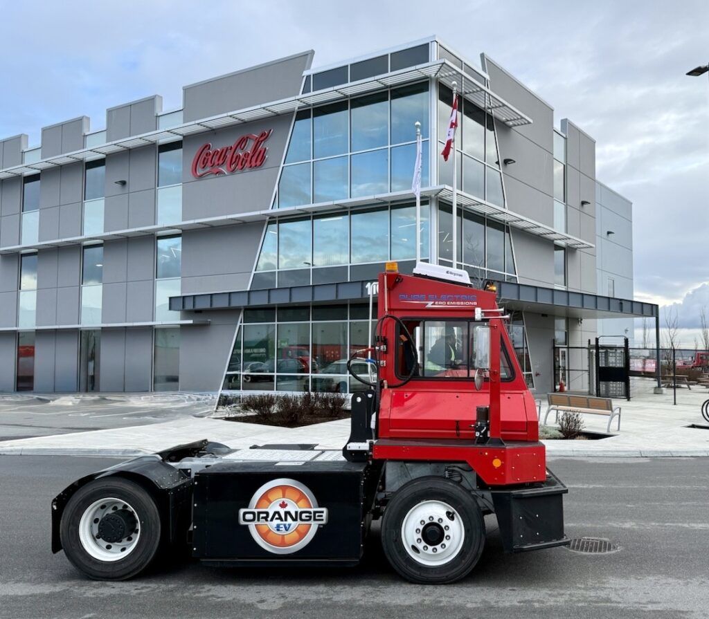 Imagem do caminhão terminal de pátio Orange EV com a marca da Coke Canada Bottling