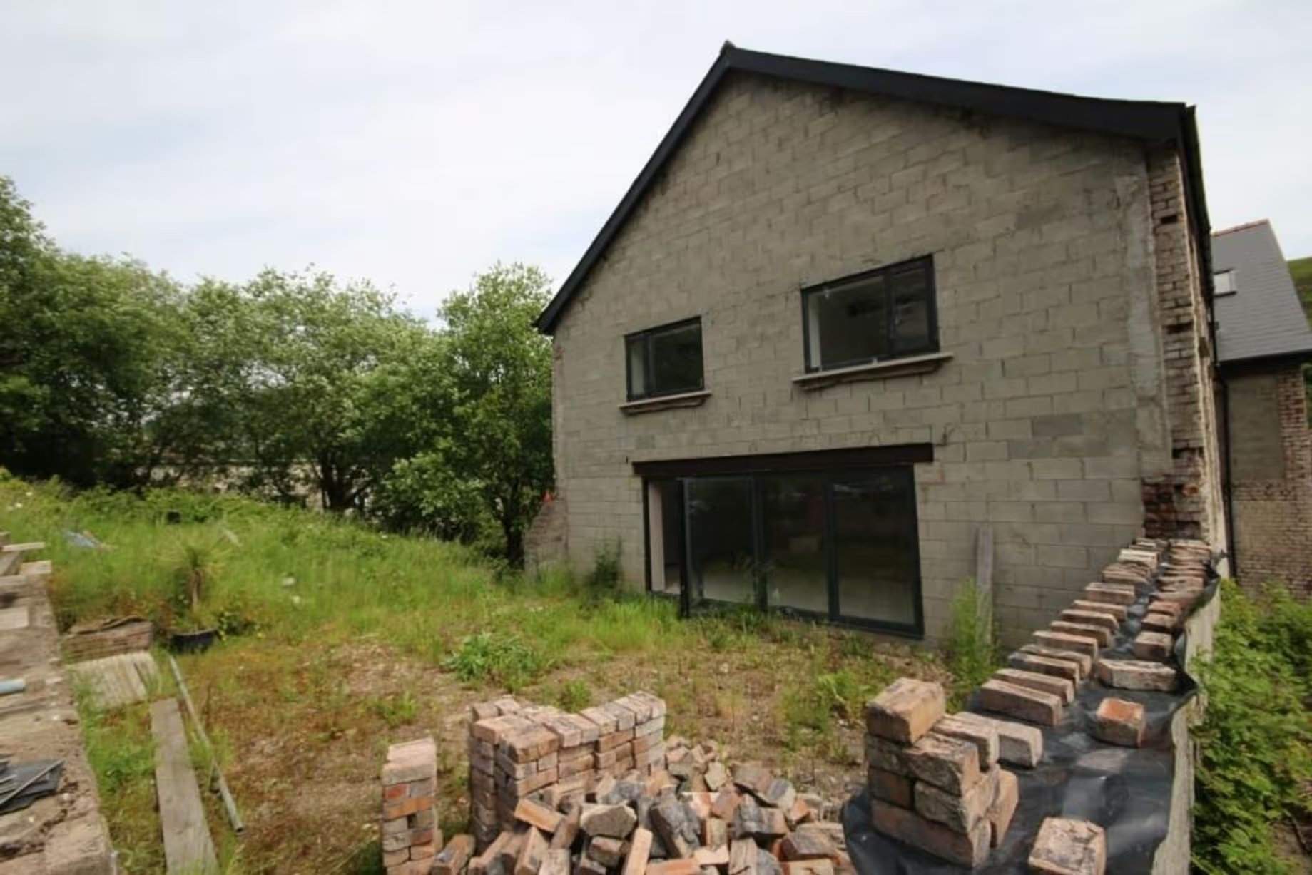Arrière du bâtiment vu du jardin arrière, deux étages, façade actuelle en parpaings, dans le Workmen's Institute de Brynsteedle partiellement rénové, mis aux enchères par Seel & Co, prix de départ 195 000 £, permis de construire pour transformation en logements obtenu