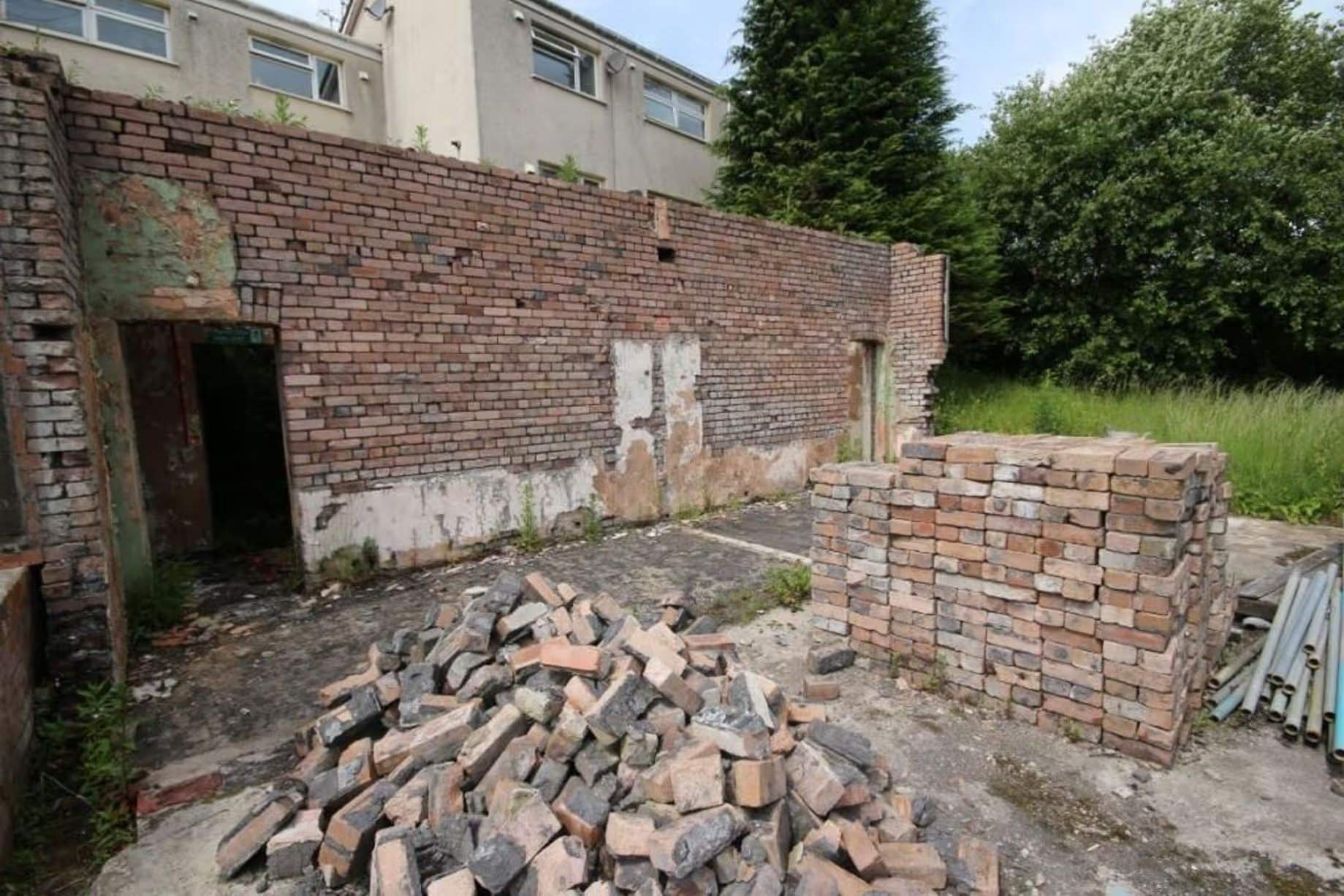 Jardin de taille considérable, avec des terrains sur les côtés et à l'arrière, ainsi que cette zone de sol dur où se trouvait autrefois une dépendance, dans le Workmen's Institute de Brynsteedle partiellement rénové, mis aux enchères par Seel & Co, prix de départ 195 000 £, permis de construire pour transformation en logements obtenu