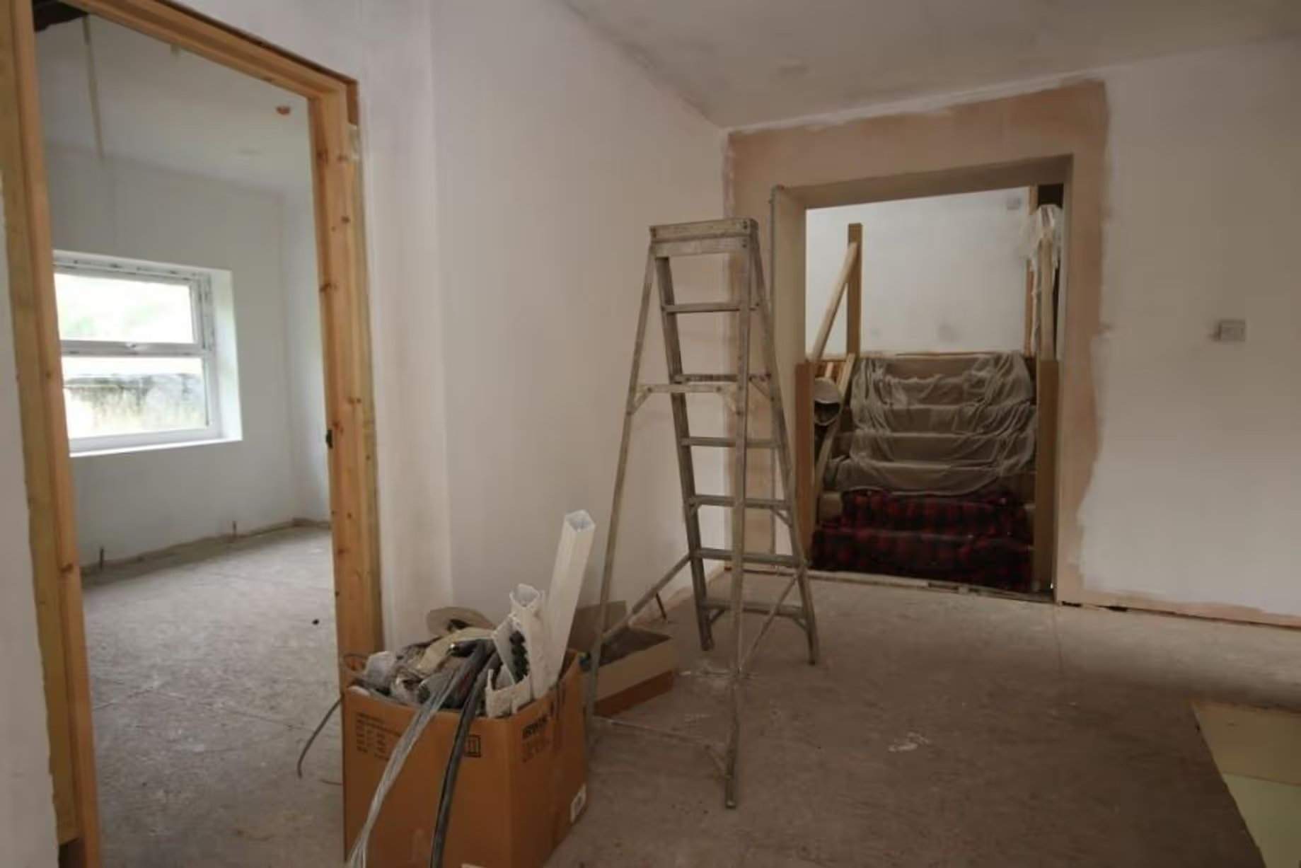 Couloir vide menant à deux pièces vides, mises à jour avec une première rénovation et de nouvelles plaques de plâtre, dans le Workmen's Institute de Brynsteedle partiellement rénové, mis aux enchères par Seel & Co, prix de départ 195 000 £, permis de construire pour transformation en logements obtenu
