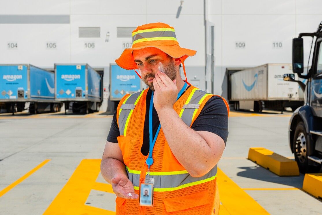 Amazon-Lagermitarbeiter in Sicherheitsweste und Helm auf einer Laderampe