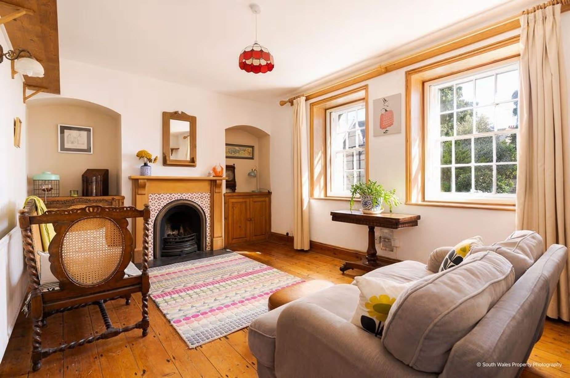 Entering the living room, this space is undoubtedly what everyone dreams of – charming wide wooden floors, a feature fireplace, alcoves, and Georgian windows – a peaceful, cosy, and charming space, Victorian end-terrace coastguard cottage, Grade II listed, for sale by David Baker (Penarth) with a guide price of over £400,000