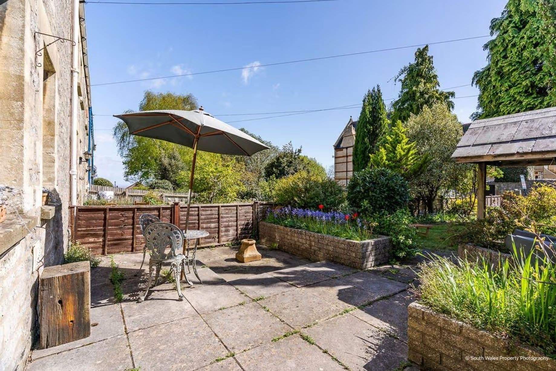 Sun-drenched flagged garden terrace, an excellent spot for relaxation or entertaining, Victorian end-terrace coastguard cottage, Grade II listed, for sale by David Baker (Penarth) with a guide price of over £400,000
