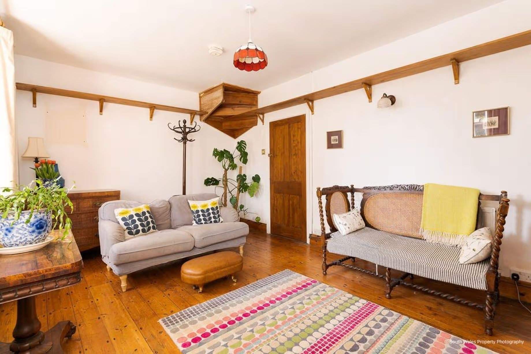 Entering the living room, this space is undoubtedly what everyone dreams of – charming wide wooden floors, a feature fireplace, alcoves, and Georgian windows – a peaceful, cosy, and charming space, Victorian end-terrace coastguard cottage, Grade II listed, for sale by David Baker (Penarth) with a guide price of over £400,000