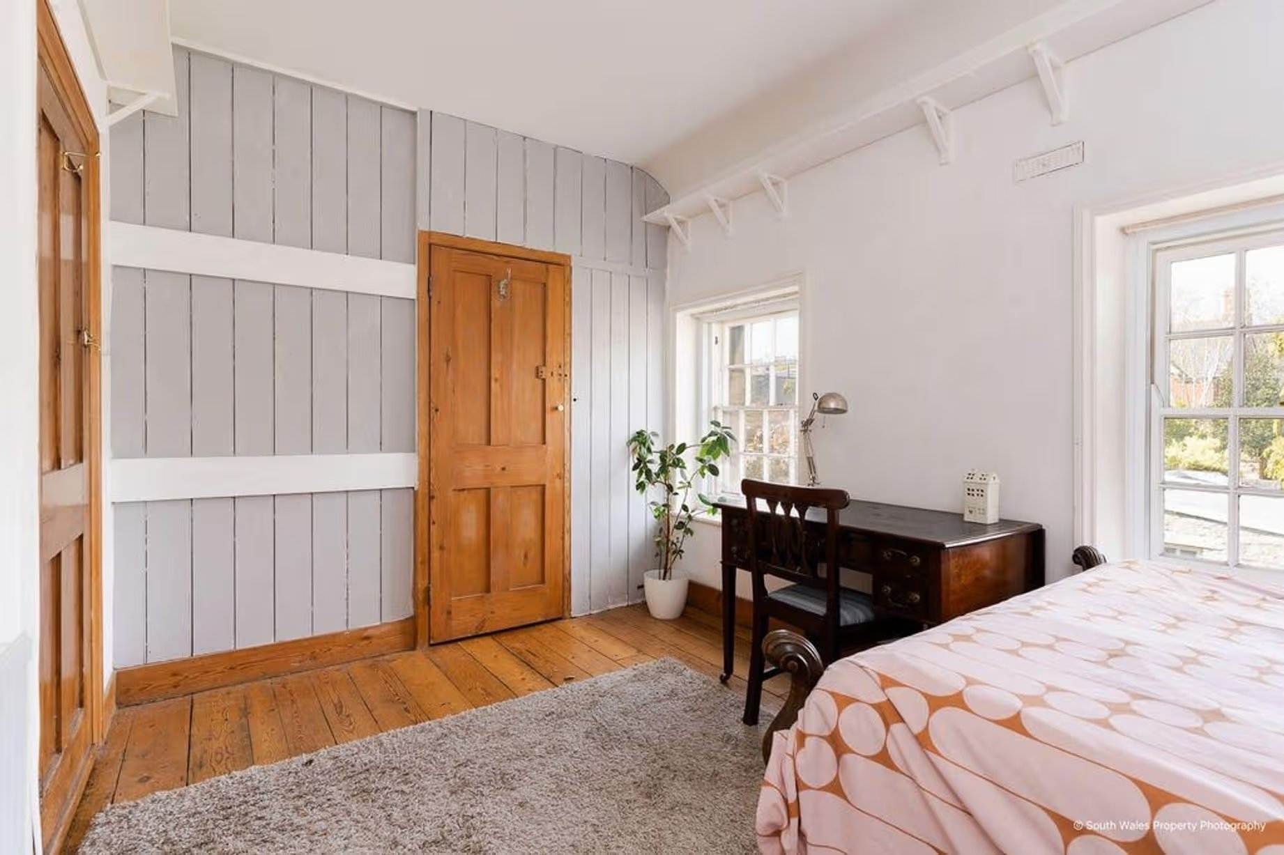 The wooden wainscoting at the end of the room, painted a soft grey, adds a more modern tone to the space, and behind the door is a built-in wall cupboard set into the wall, Victorian end-terrace coastguard cottage, Grade II listed, for sale by David Baker (Penarth) with a guide price of over £400,000