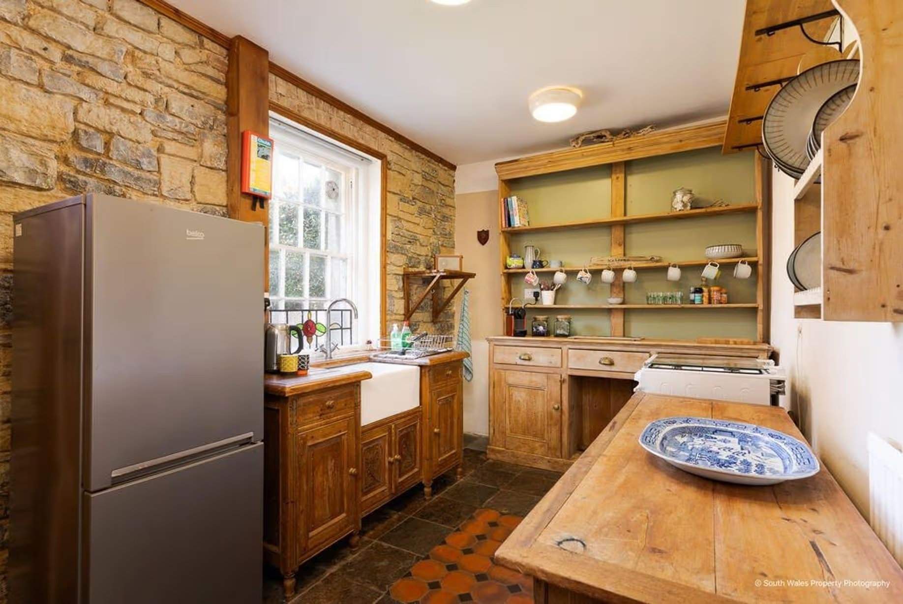 The kitchen-diner is another room full of character, from the quarry tiles to the chunky freestanding wooden furniture – more suited to this Victorian end-terrace coastguard cottage than a modern fitted kitchen, Grade II listed, for sale by David Baker (Penarth) with a guide price of over £400,000