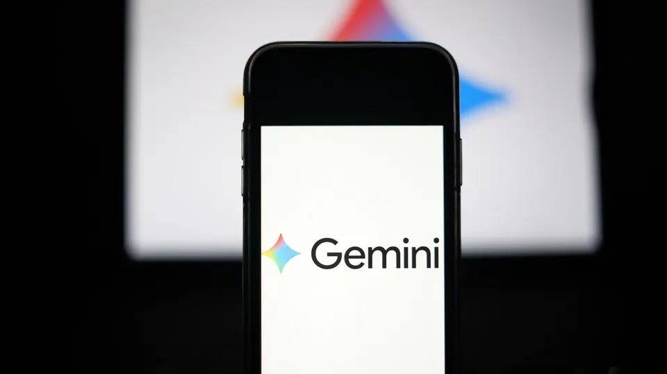 Un smartphone affiche le logo lumineux de Google Gemini sur un fond sombre.