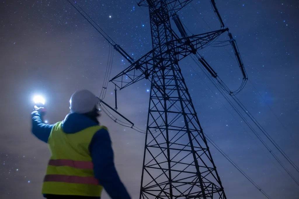 مهندس يعمل على خطوط الجهد العالي ليلاً.