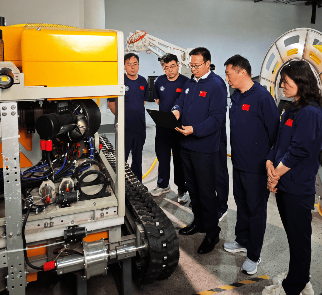 The research team conducts technical discussions around deep-sea exploration equipment.