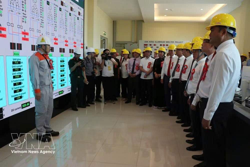 Le général Phan Văn Giang, membre du Bureau politique du Comité central du Parti, vice-Premier ministre et ministre de la Défense, visite avec les délégués la zone de contrôle technique de l'usine d'électrolyse de l'aluminium de Đắk Nông. Photo : VNA