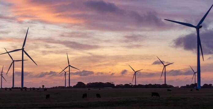 Aerogeneradores bajo un cielo púrpura y naranja al atardecer
