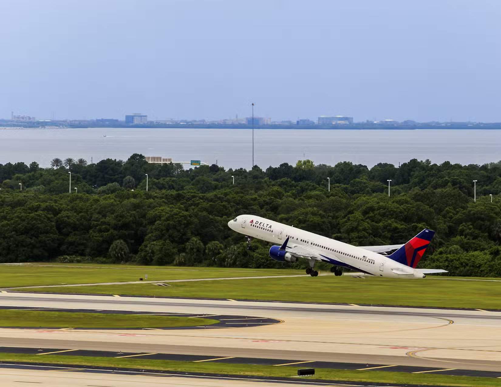 佛罗里达州坦帕，2015年5月23日，坦帕国际机场。一架达美航空波音757喷气式飞机起飞，背景是坦帕湾。